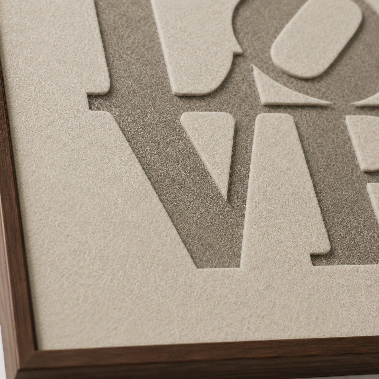 Modern LOVE wandkunstwerk van gelaagd akoestisch vilt met uitgesneden typografie en houten lijst.