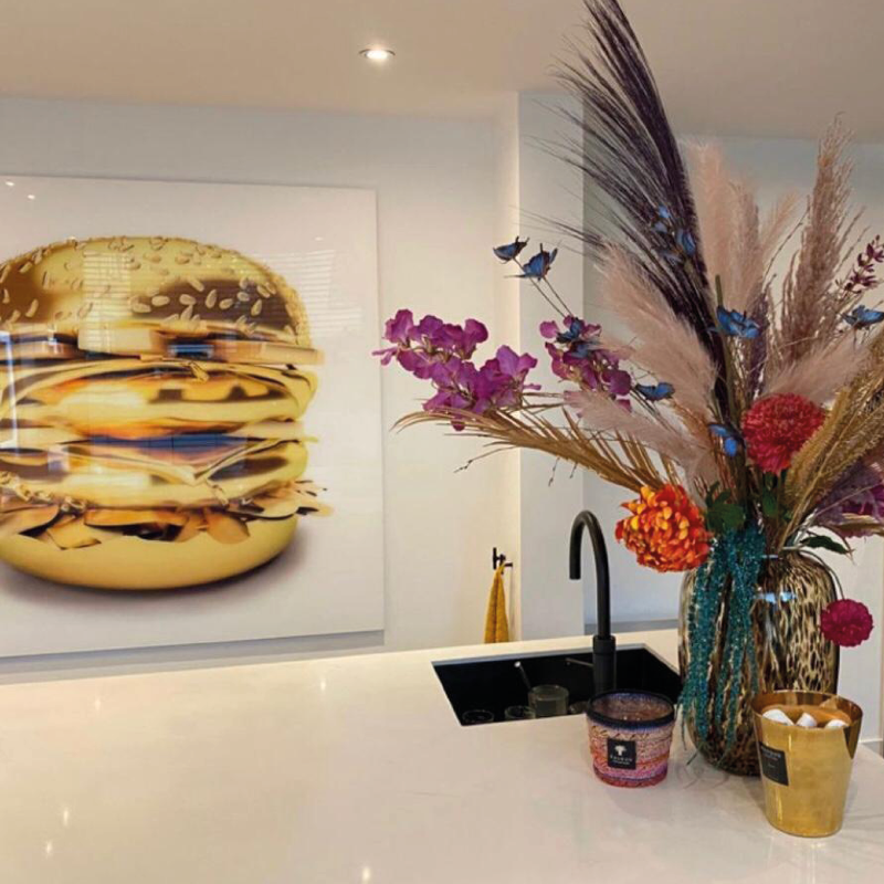 schilderij op plexiglas met een gouden hamburger in een moderne keuken
