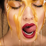 Sexy vrouw met honing over haar gezicht op een schilderij van plexiglas